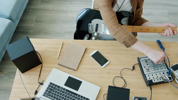 Slow Motion of Male Musician Recording Music Playing Guitar Using Modern Equipment at Home alt
