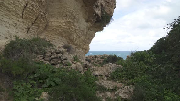 Walking Around il-Qarraba Rock with Grass Growing on the Limestone and Ground All Around alt