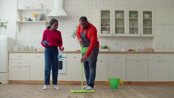 African Daughter Helping Single Father Mopping Floor alt