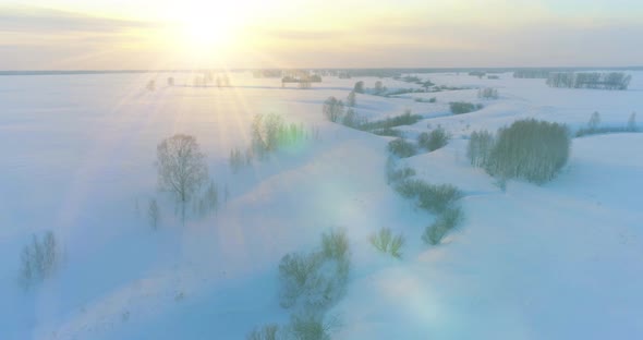 Aerial View of Cold Arctic Field Landscape Trees with Frost Snow Ice River and Sun Rays Over Horizon alt