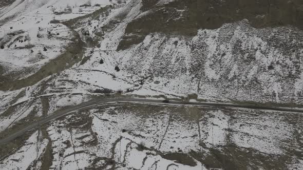 road in the mountains with snow mountain in background in autumn season. alt