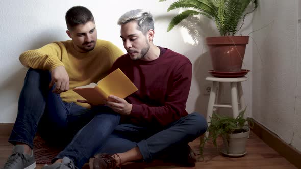 Lgbt Gay Couple Hugging and Reading Book Together Indoor at Home alt