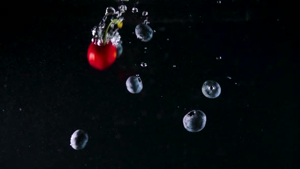 Blueberries and Cherries Fall Down Into Water with Bubbles alt