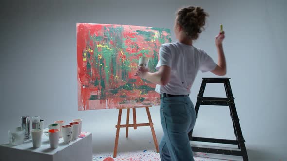 Slow Motion Female Artist Draws with a Brush on a Large Canvas in a White Room a Talented Artist alt