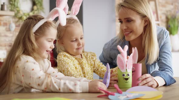 Video of mother playing with daughters using handmade Easter toys. alt