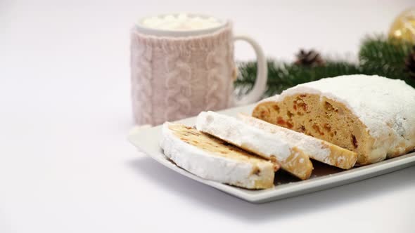 Sliced Traditional Christmas Stollen Cake on Ceramic Plate and Cup of Cocoa and Marshmallow alt