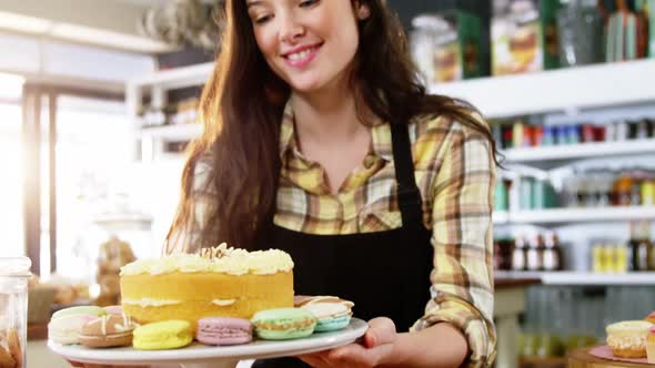 Waitress holding dessert on cake stand in cafe alt