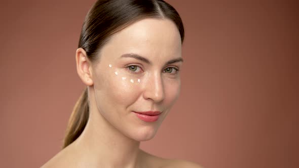 Young Woman with Cream Dots Under Eye