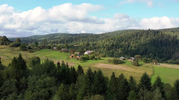 Birds eye view of little settlement among beautiful nature, mountains, and forests