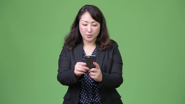 Mature Beautiful Asian Businesswoman Using Phone alt