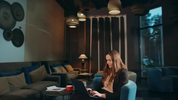 Smiling Woman Using Laptop Computer in Hotel. Business Woman Working Laptop alt