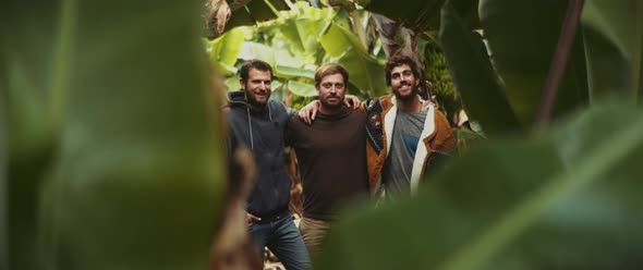 Three man standing together in banana field and smiling alt