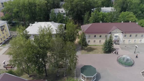 People walks along a beautiful alley in a provincial city. Poplar fluff flies 06 alt