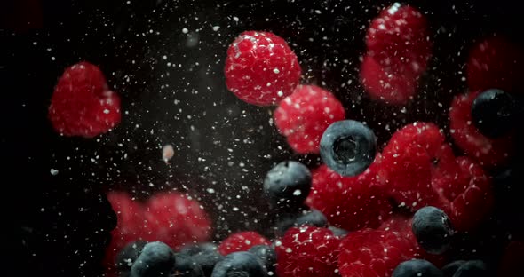 Raspberry, blueberry and mulberry falling into transparent water. Sweet fresh berries alt
