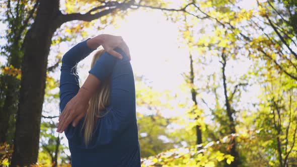 Woman Does Sports Exercises Standing in Autumn Forest