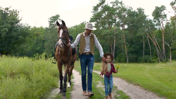 Cowboy with His Daughter Walking with a Horse on a Forest Road alt
