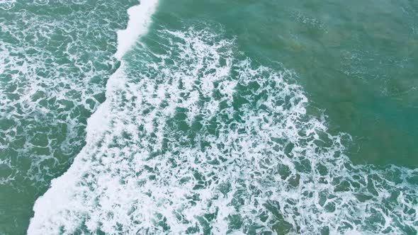Aerial top view of ocean blue waves break on a beach.sunlight and transparent for seascape. alt