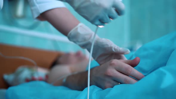 the doctor puts a heart rate monitor on the patient's finger on a blurred background.