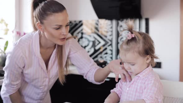 Mother Cooking Together with Little Daughter at Kitchen