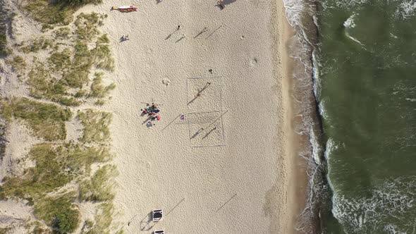 AERIAL: Young People Plays Volleyball on a Sand near Sea in Nida