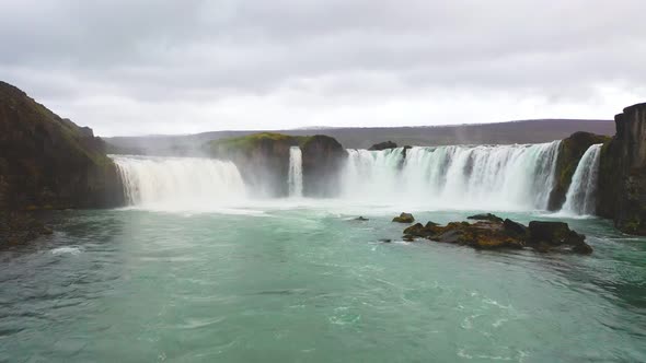 Aerial drone shot flying above the Mountain waterfalls during summer. alt