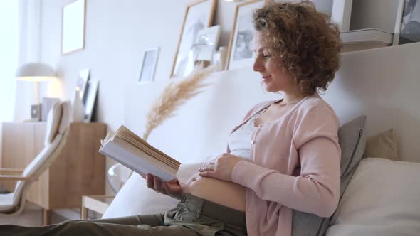 Pregnancy, Rest, People And Expectation Concept - Happy Pregnant Woman Lying In Bed With Book At alt