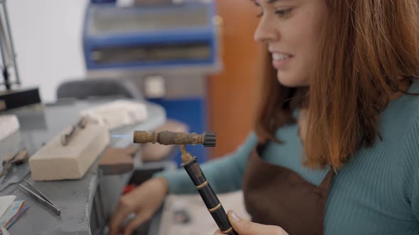 Female Jeweler Holding Gas Blowtorch Crafting In Workshop alt
