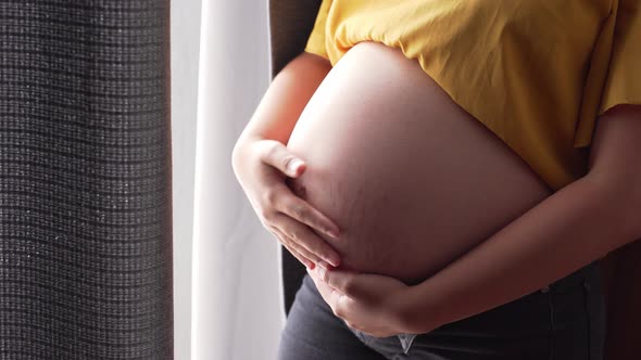 a pregnant woman holding belly alt