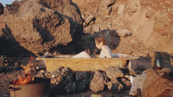 Woman in Bathtub Posing for Camera in Dystopian World alt