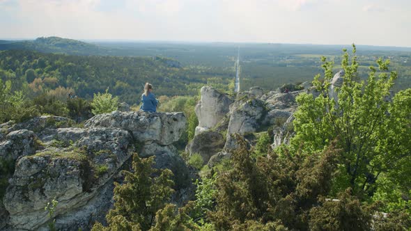 Woman Sitting on a Top of Mountain