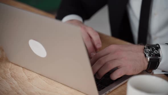 Close Up of Businessman Laptop on Desk and Male Using It. Professional Male Worker in Suit.