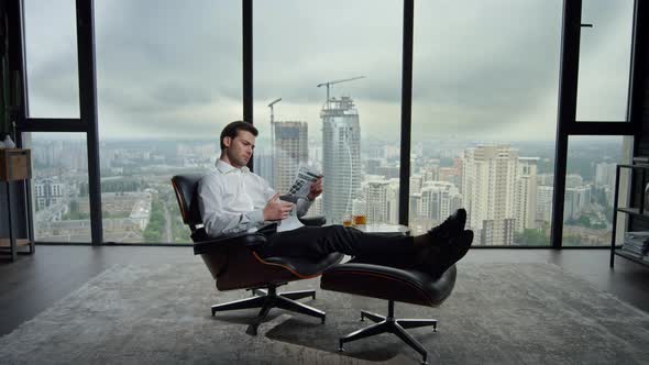 Businessman Resting in Chair with Newspaper. Manager Reading Newspaper in Office alt