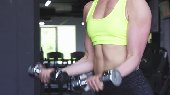 Cropped Shot of a Strong Athletic Woman Lifting Dumbbells alt