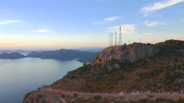 Group of Telecommunication Antennas on Top of Mountain Hill and Sea View alt