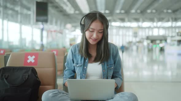 travel vacation concept,asian female woman wear headphone hand use laptop alt