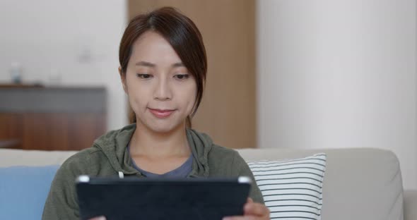 Woman watch on tablet computer at home alt