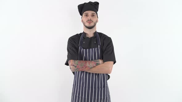 Serious Tattooed Chef in Uniform with His Arms Crossed Looking at Camera alt