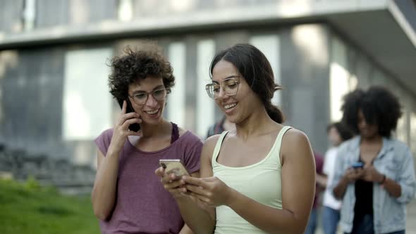 Happy Women Looking at Smartphone and Laughing alt