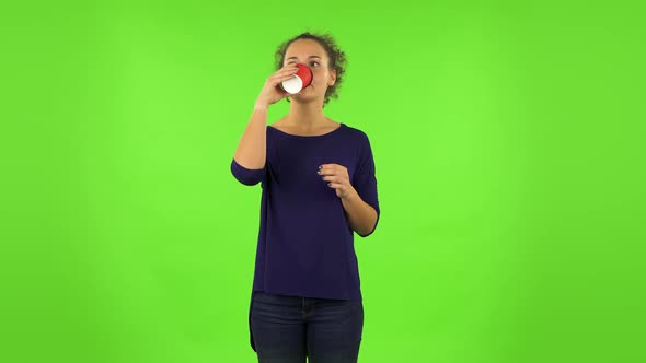 Curly Woman Drinking Unpalatable Coffee and Is Disgusted . Green Screen alt