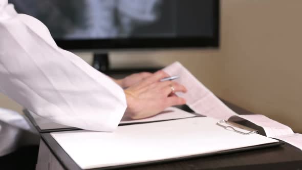 Doctor cardiologist makes records of the result of the analysis of the cardiogram in the hospital. alt