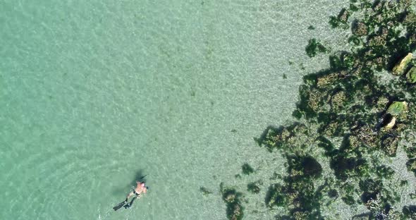 Top dawn view man diver snorkeling in crystal clear transparent water, alt