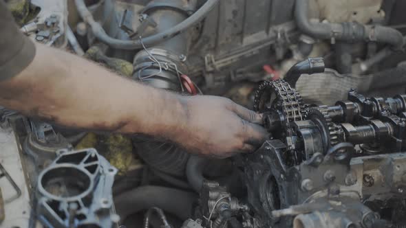 Mechanic with His Bare Hands Screws the Bolt