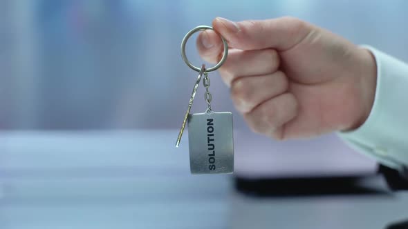 Solution Word on Keychain Hand Showing to Camera, Accepting Opportunity, Startup alt
