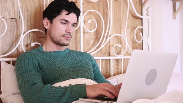 Man Celebrating Success While Working on Laptop Sitting on Couch alt
