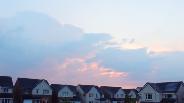Hot, warm, peach-coloured sky cloudy timelapse with houses