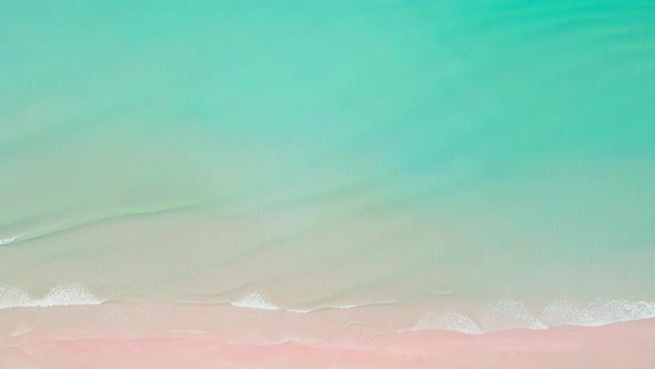 4K Aerial view top view of drone, blue sea waves and beautiful pink sand beach. alt