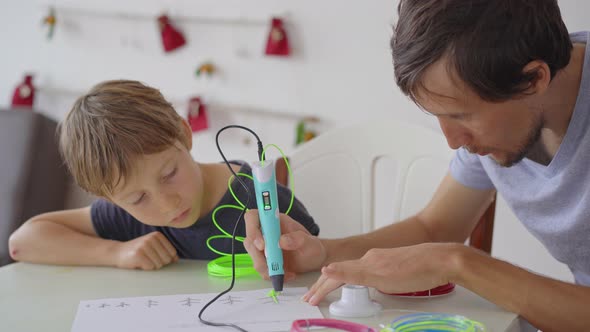 Close Up shot of a little boy that is using a 3d pen alt