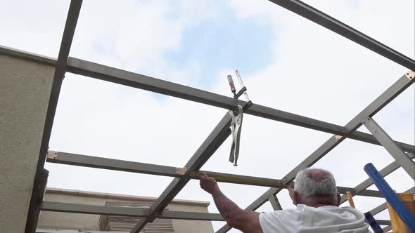 adult man constructing building roof measure and hammer house repair renovation