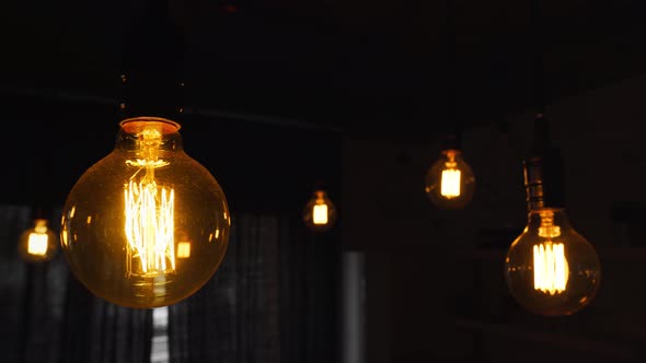 Big Vintage Incandescent Light Bulbs Hanging in the Dark Kitchen