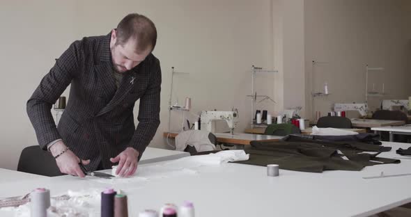 The Fashion Designer Cutting a Cloth Curve on a Desktop in Dress Atelier alt